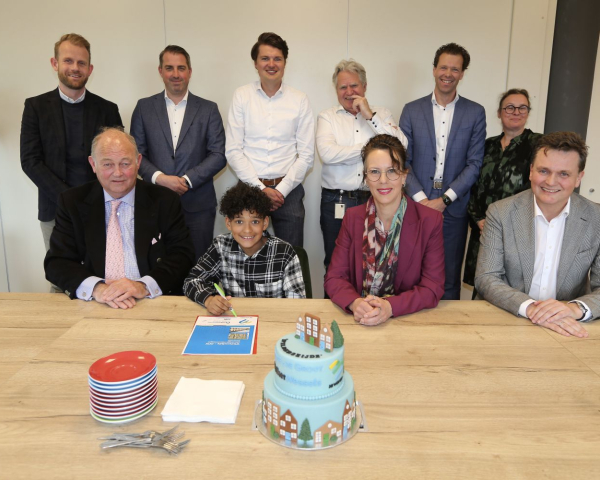 Groepsfoto van mensen achter een tafel met taart